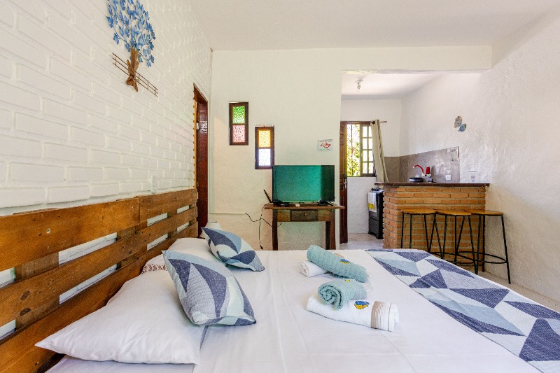 Quarto do chalé Suíte com cama de casal e bancada de cozinha
